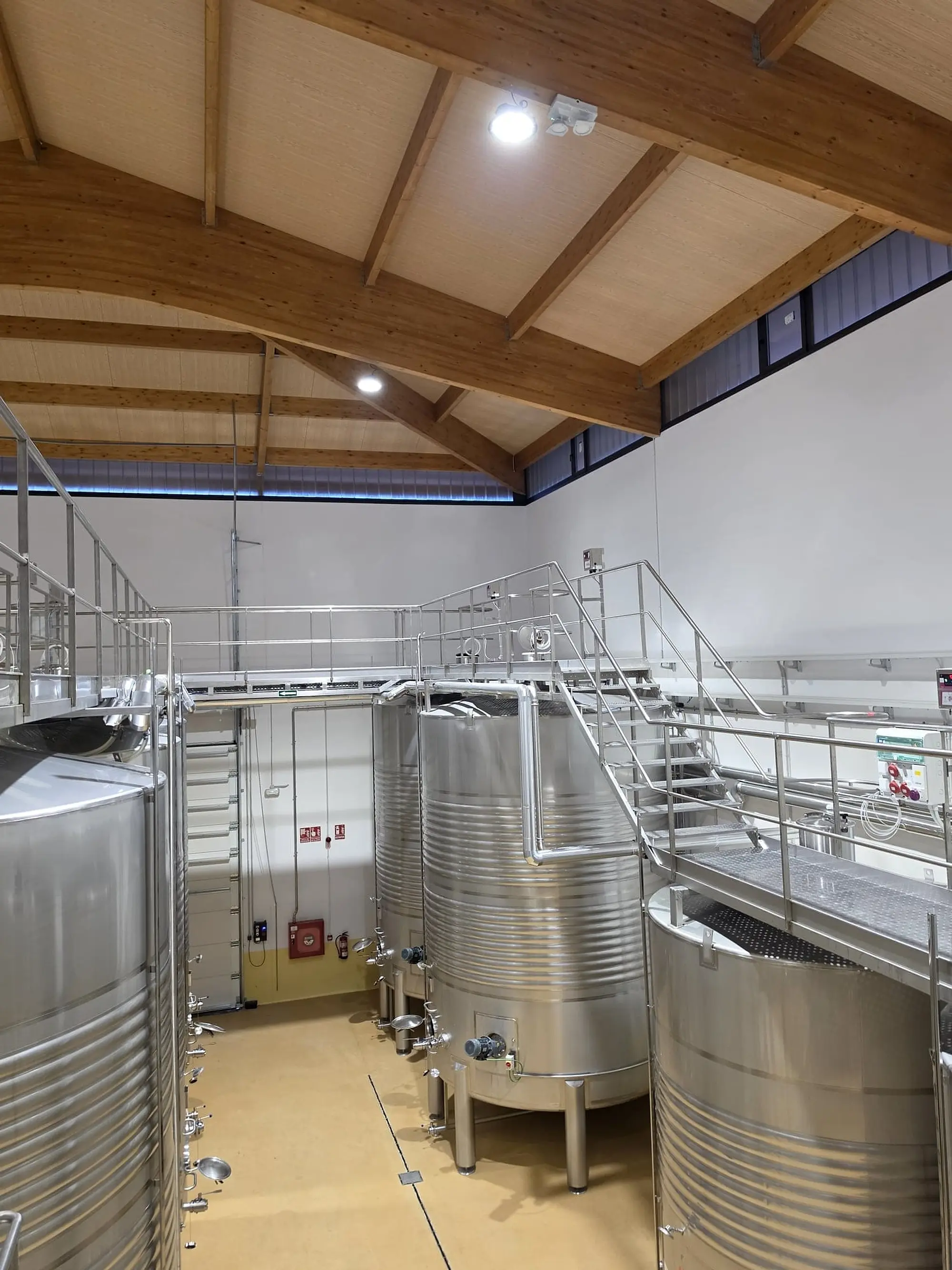 Depósitos de acero y pasarela metálica en la nueva sala, bajo un techo de madera