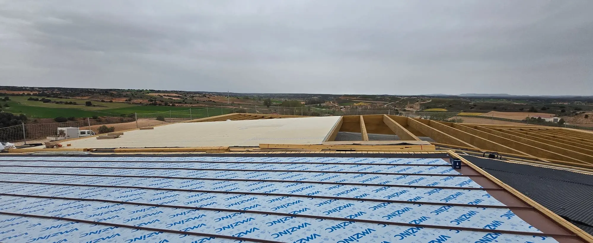 Cubierta en obra con láminas de zinc protegidas, con campos al fondo