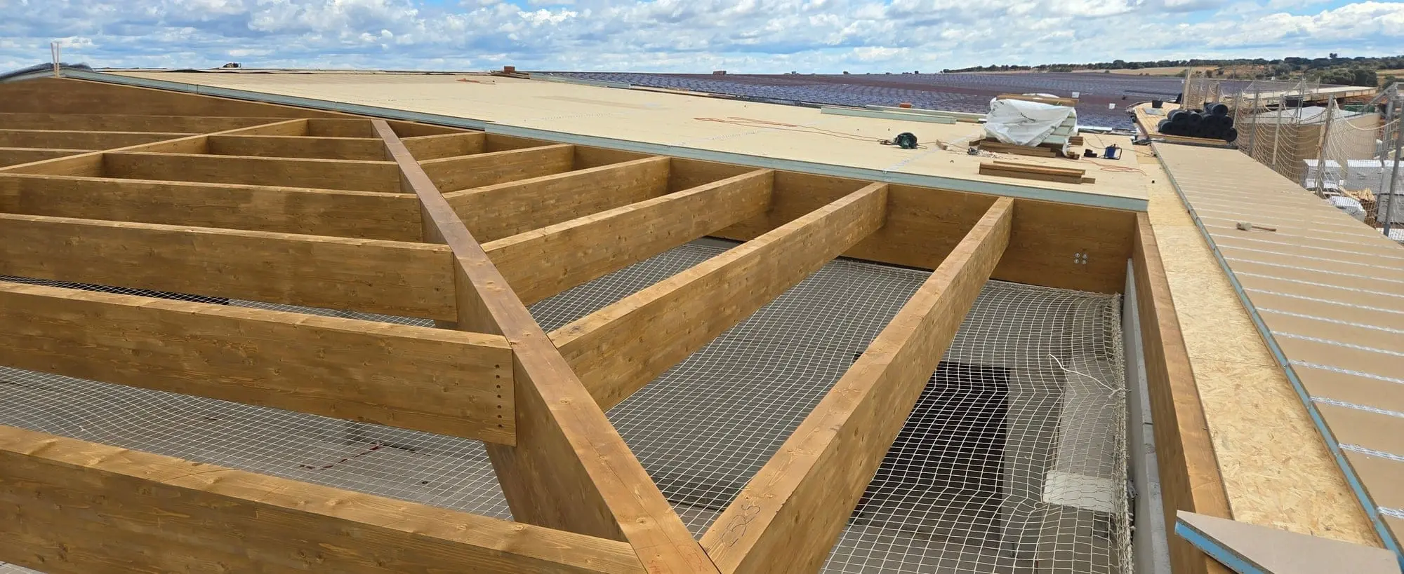 Viguetas de madera laminada de la cubierta con la red de seguridad debajo